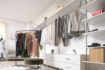 An organized walk-in closet with clothes sorted on racks and shelves